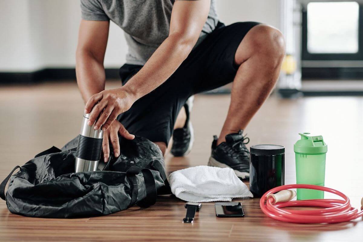 Gym essentials: man getting a tumbler from his bag