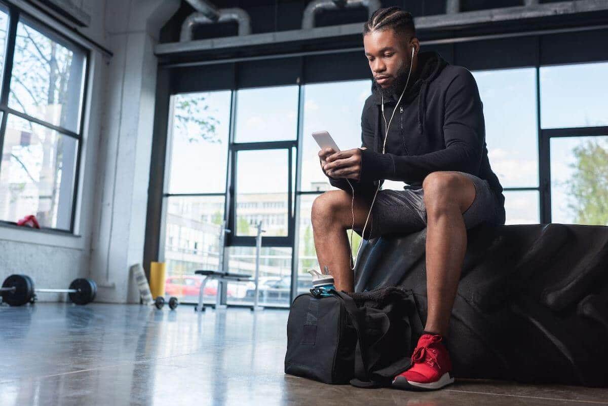 Gym essentials: man listening on his mobile phone