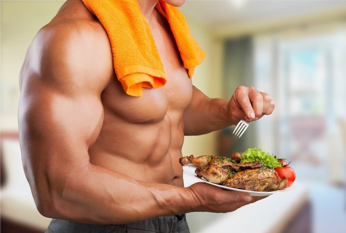 How much protein can your body absorb: muscular man eating chicken