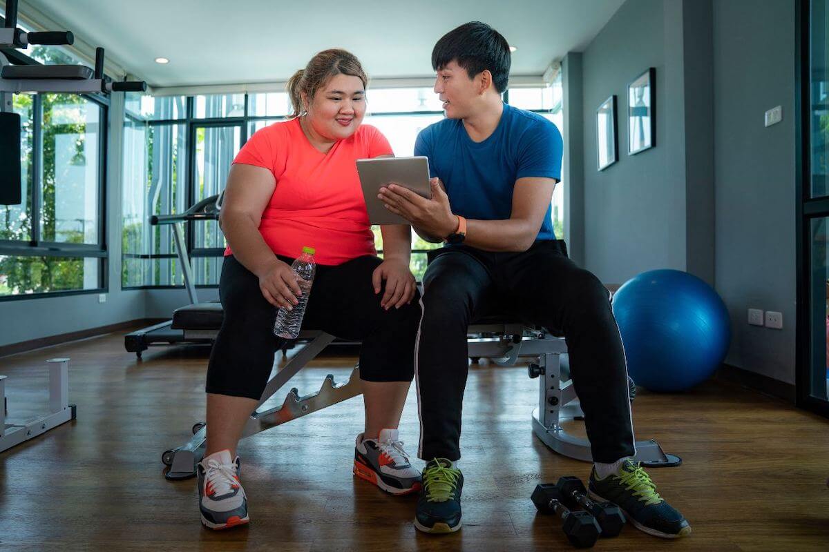 Gym essentials: trainer showing a client something from the tablet