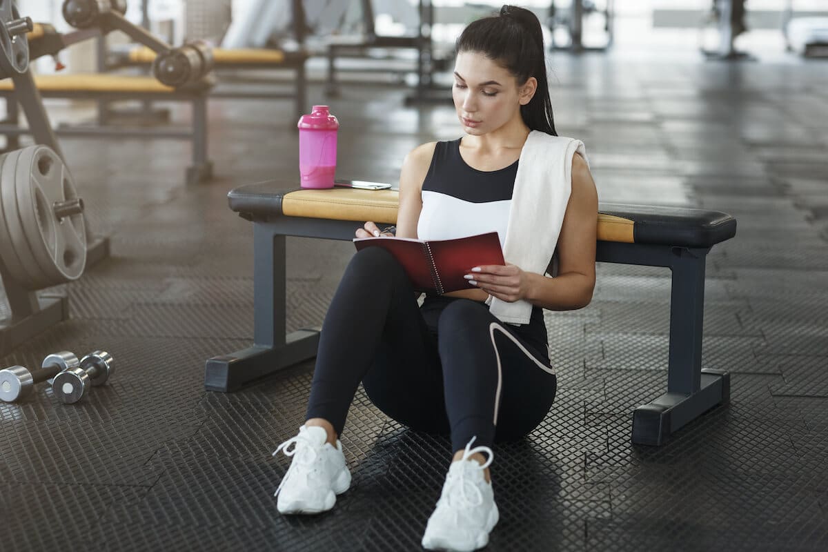 Athlete writing her workout plan in her notebook