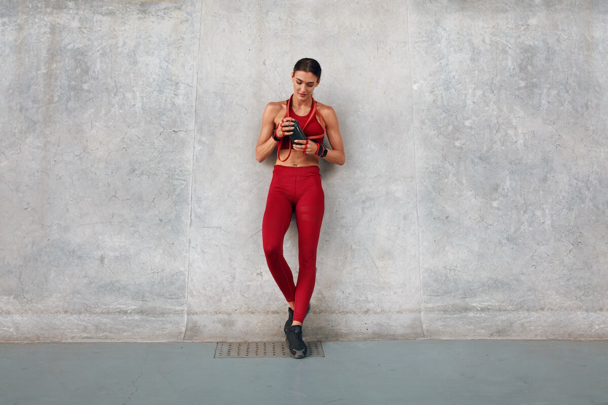 Post workout supplements: athletic woman holding a tumbler