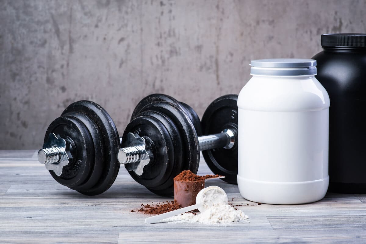 How long does it take to build muscle: dumbbells and jars of protein powder