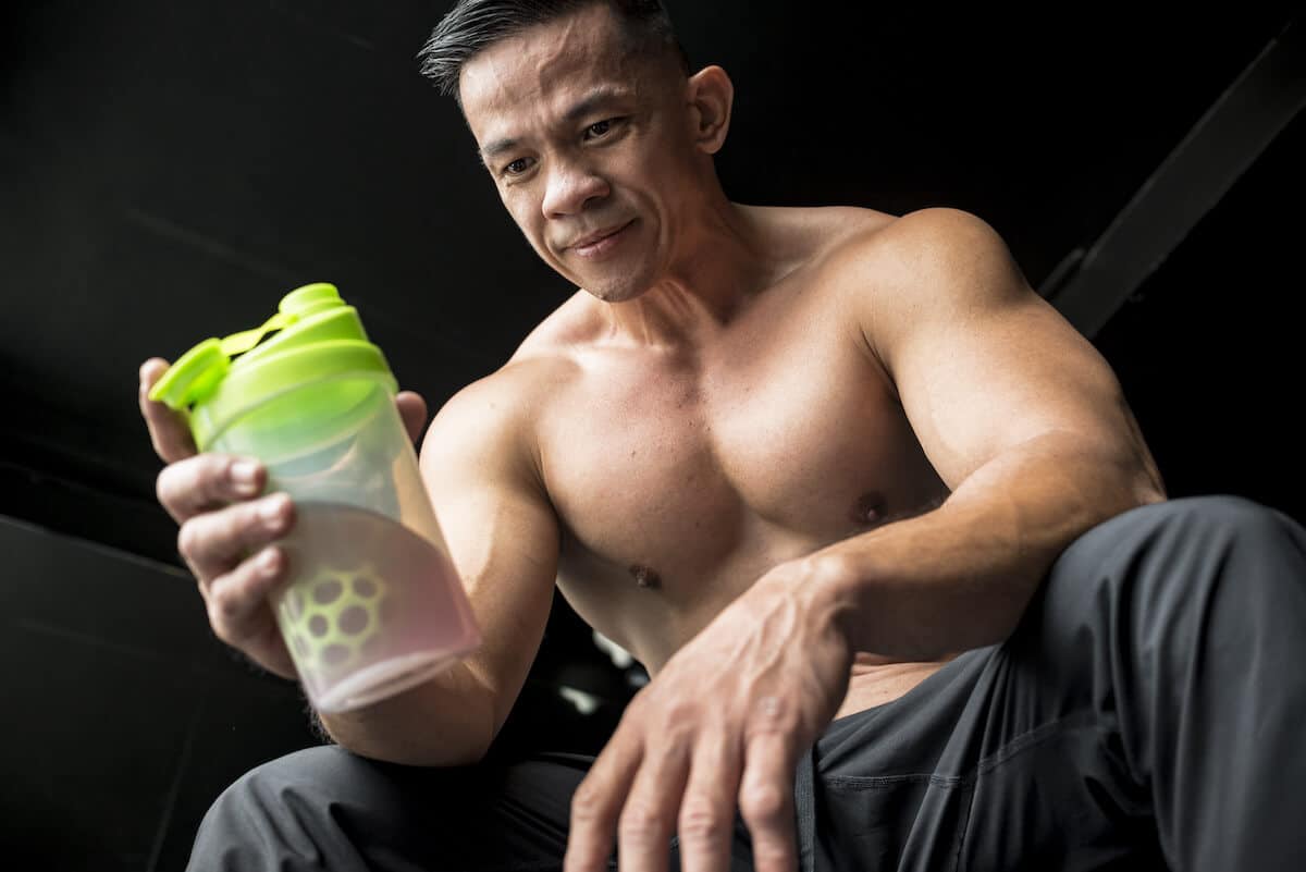 Pre workout ingredients: fit man holding a sports drink