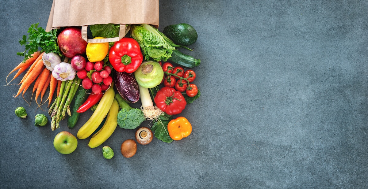 Paper bag with fruits and vegetables overflowing from it