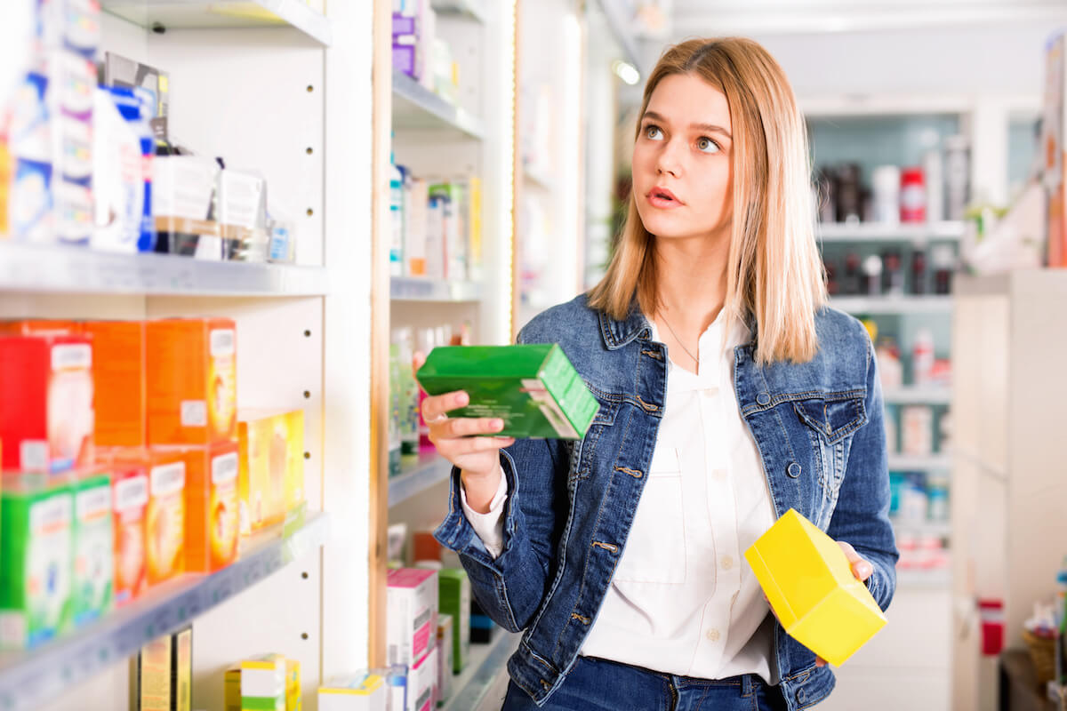 Woman choosing supplements at a pharmacy