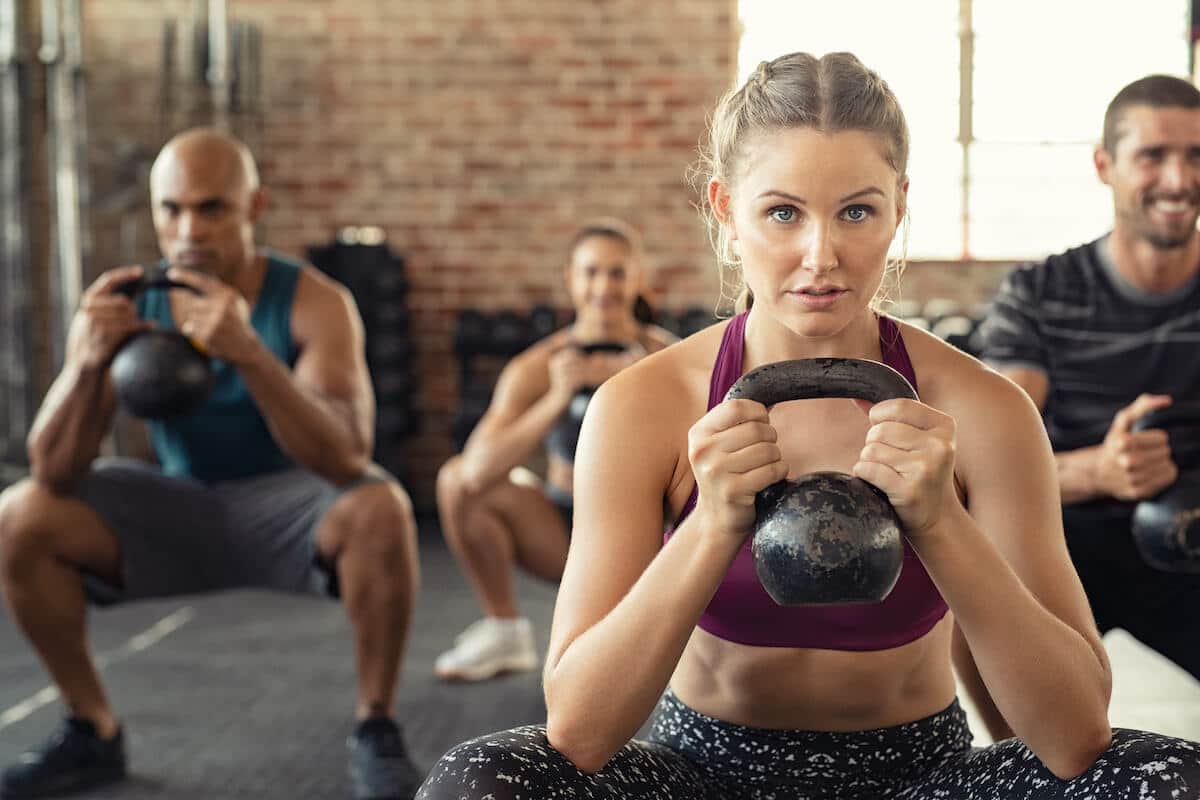 BCAA for women: group of people exercising using a kettlebell