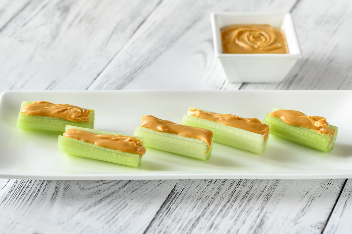 High protein low carb meals: celery stalks with peanut butter on a plate