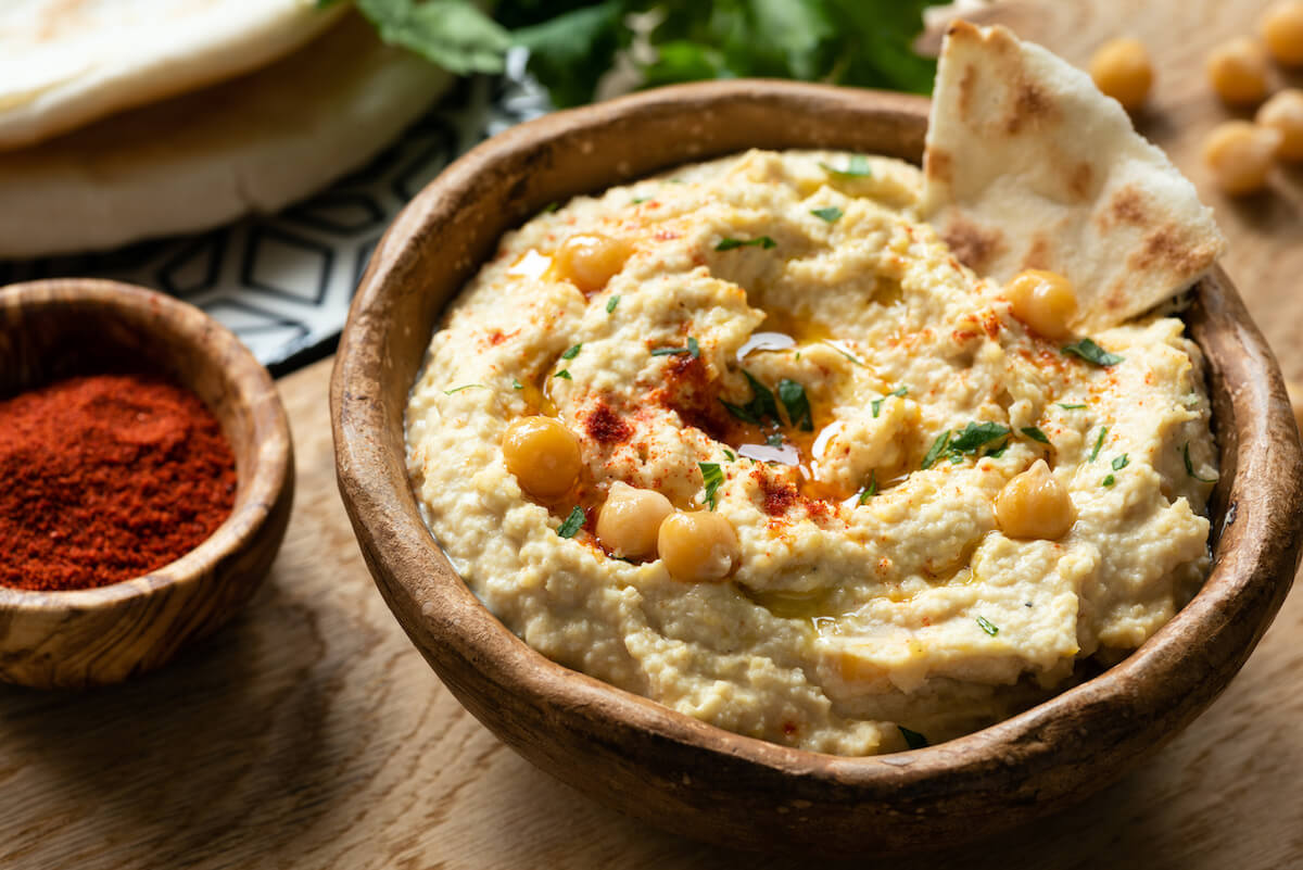 High protein vegan snacks: hummus with pita bread in a bowl