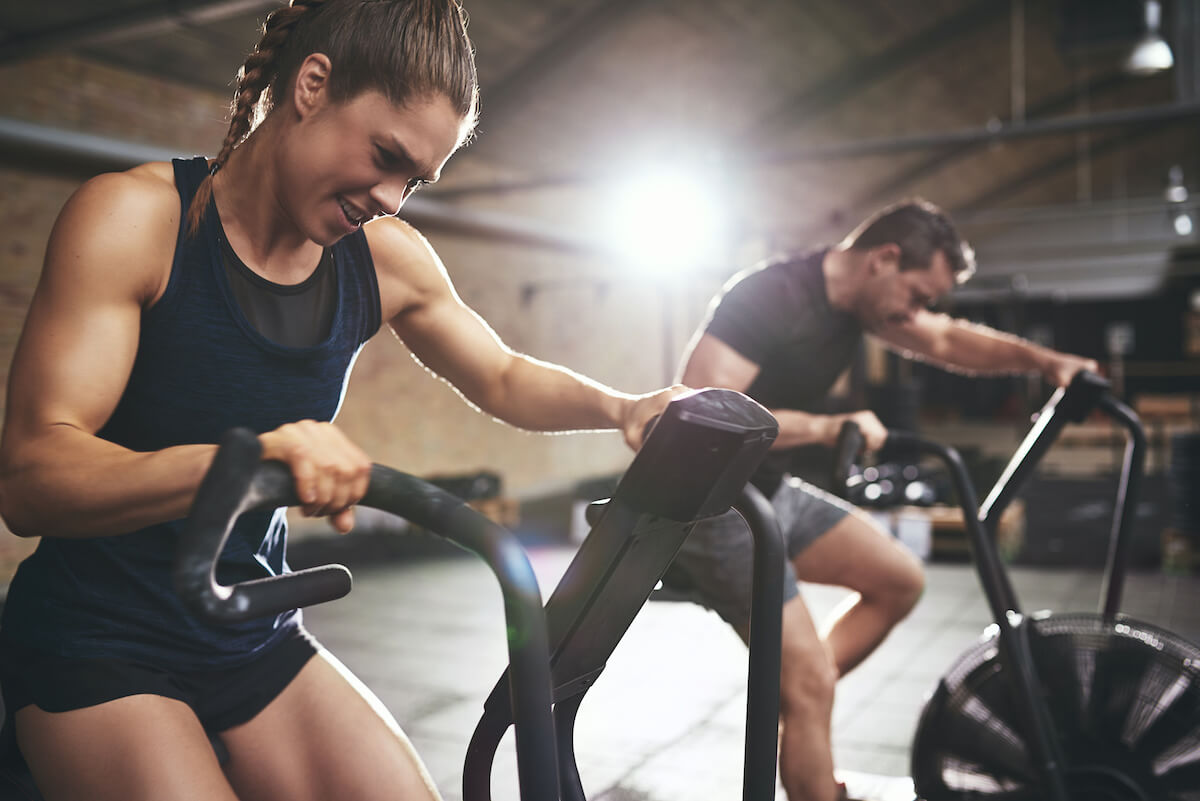 How often should you workout: man and woman using air bikes