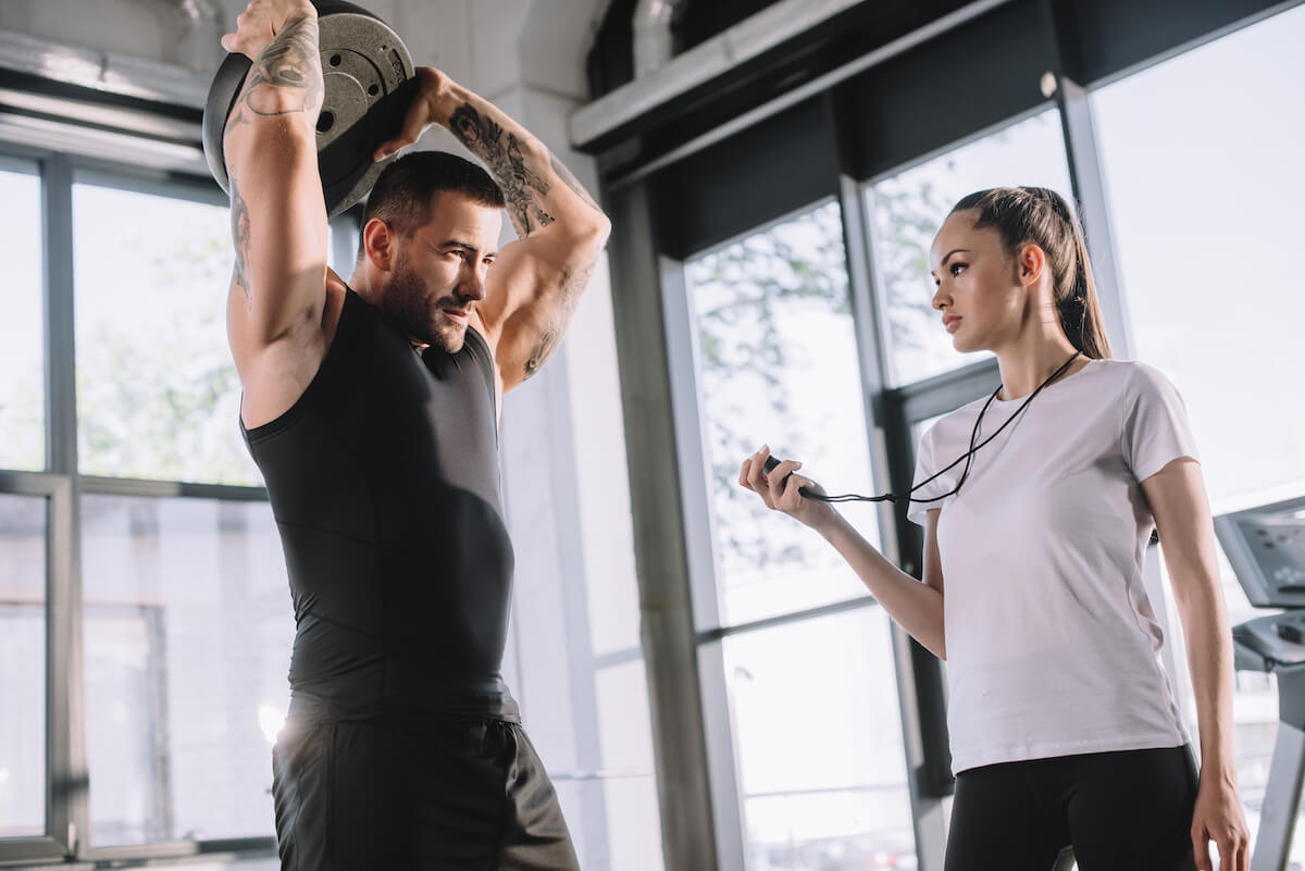 Man carrying a plate while a coach is using a timer