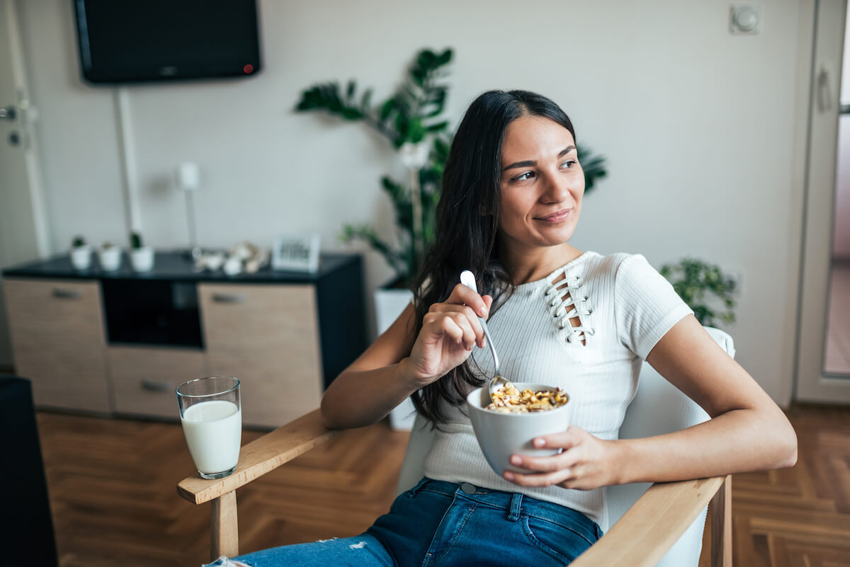Woman eating a bowl of granola