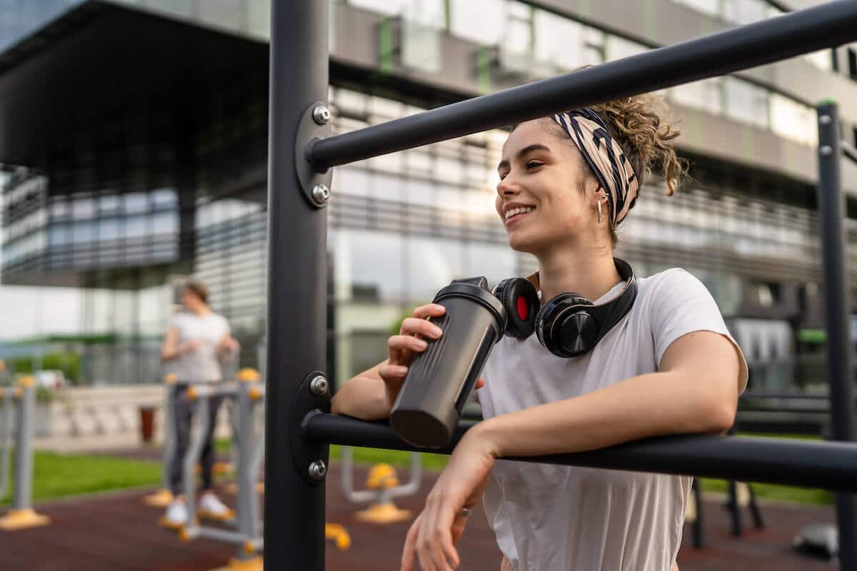 Essential vs nonessential amino acids: woman holding a tumbler after working out