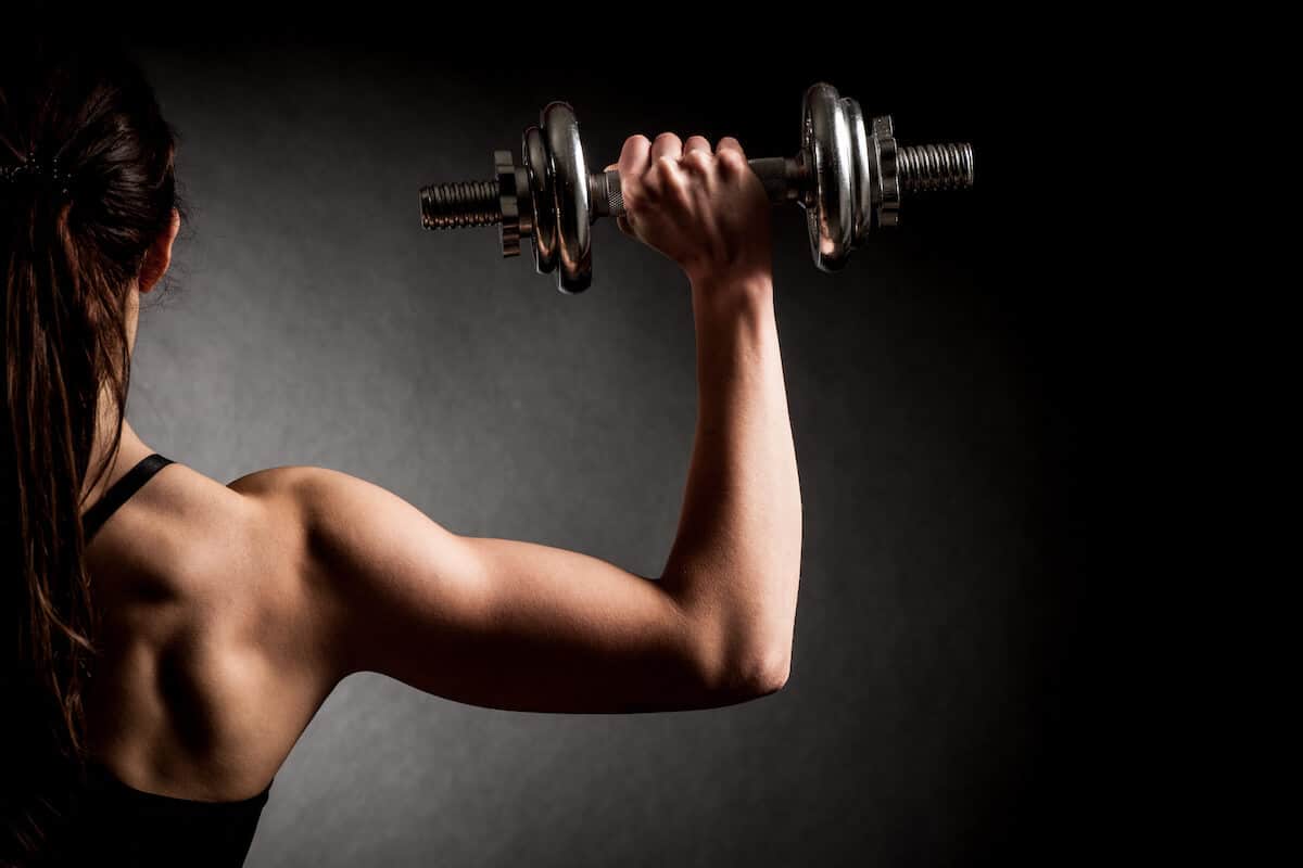 Hypertrophy vs strength: woman working out using a dumbbell