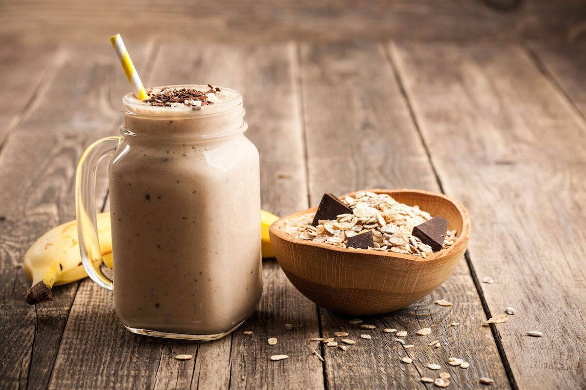 Banana chocolate smoothie and some oats and chocolates in a bowl