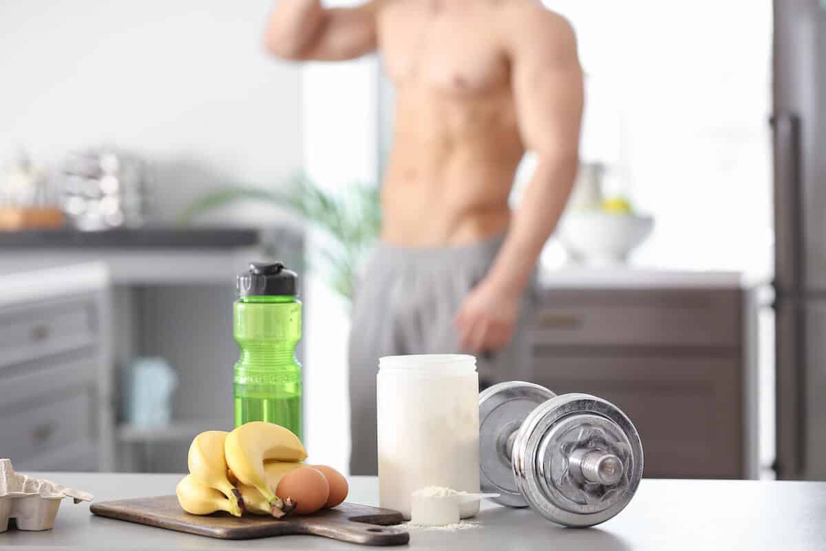 How to increase protein intake: bananas, eggs, protein powder, tumbler and a dumbbell on a table