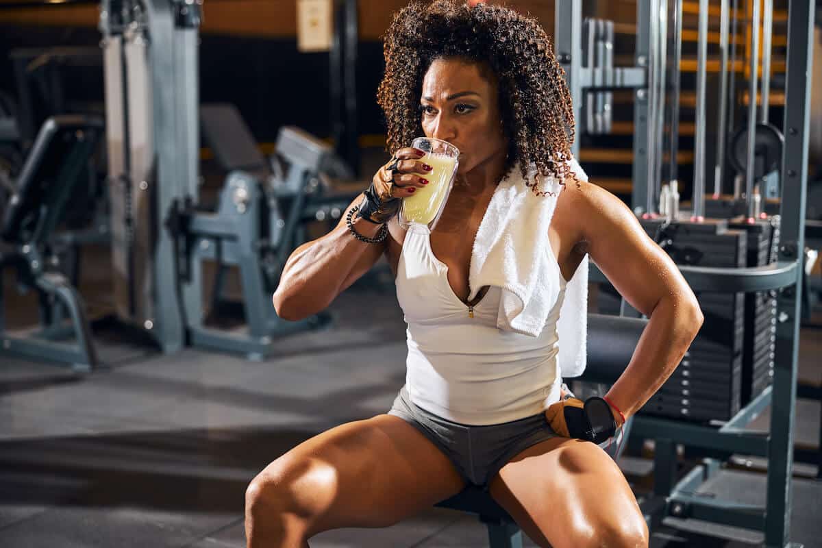Best amino acids for muscle growth: bodybuilder drinking protein shake from a glass