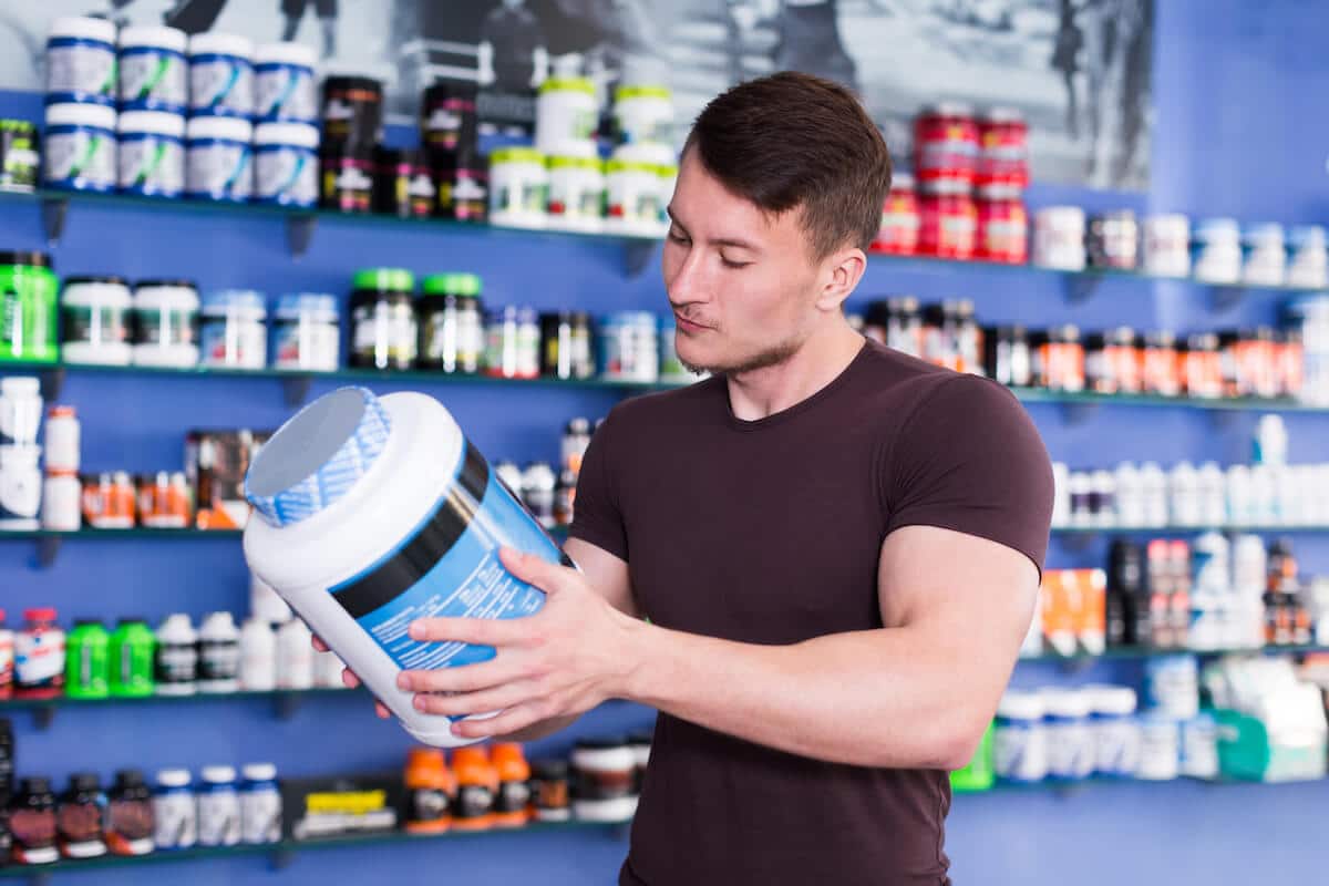 Man holding and reading a protein jar