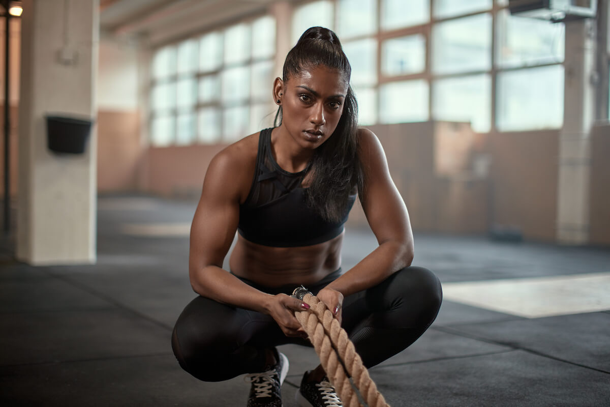 Woman holding battle ropes and looking at the camera
