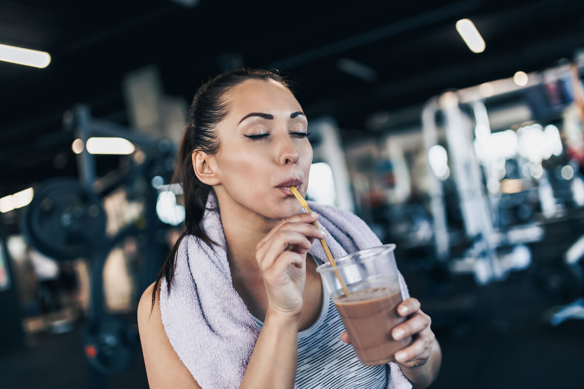 Does protein make you gain weight: woman sipping her protein shake