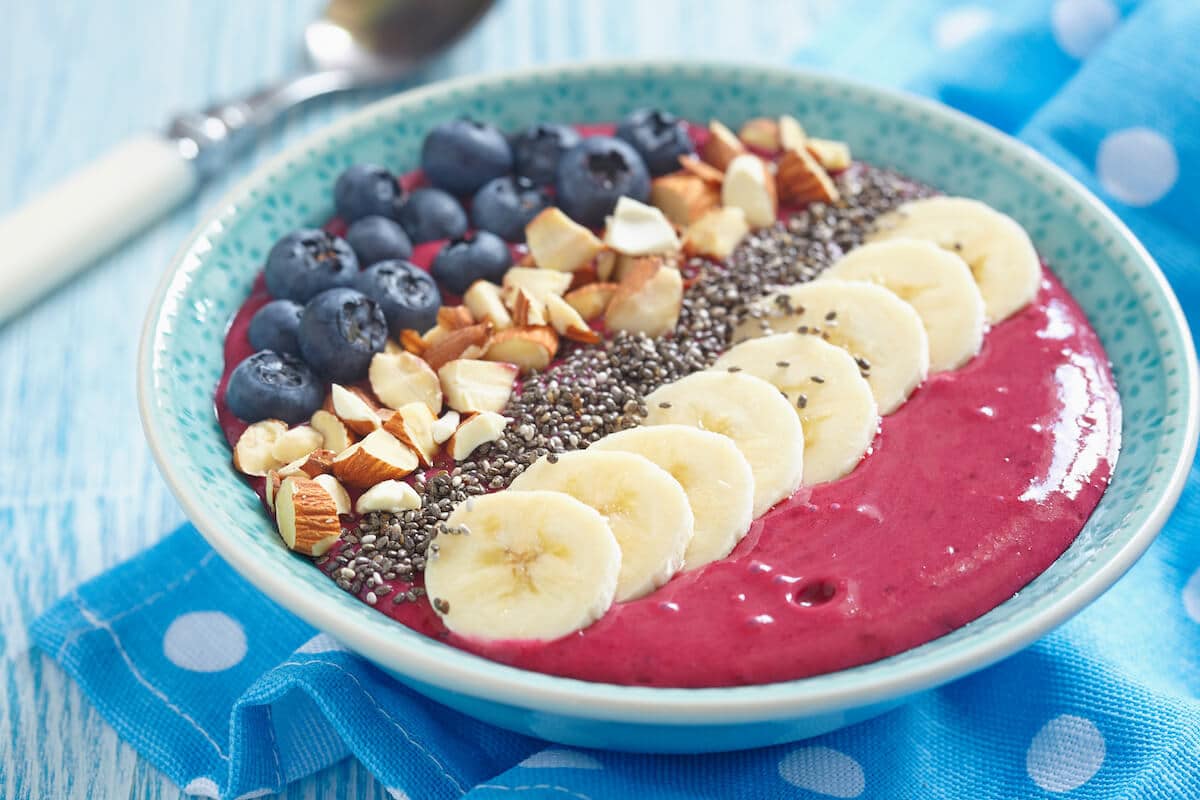 Bioavailability of nutrients: berry smoothie, banana, and almonds in a bowl