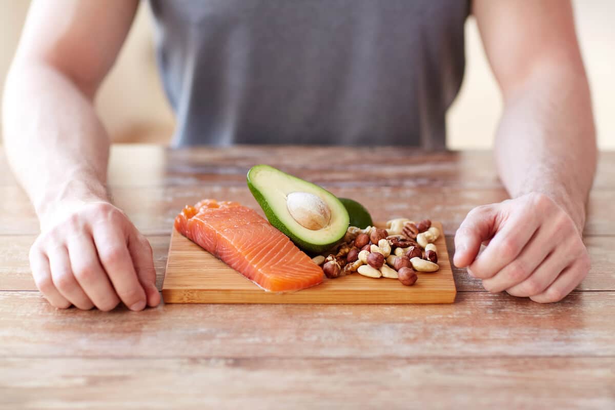 Avocado, salmon, and nuts on a chopping board