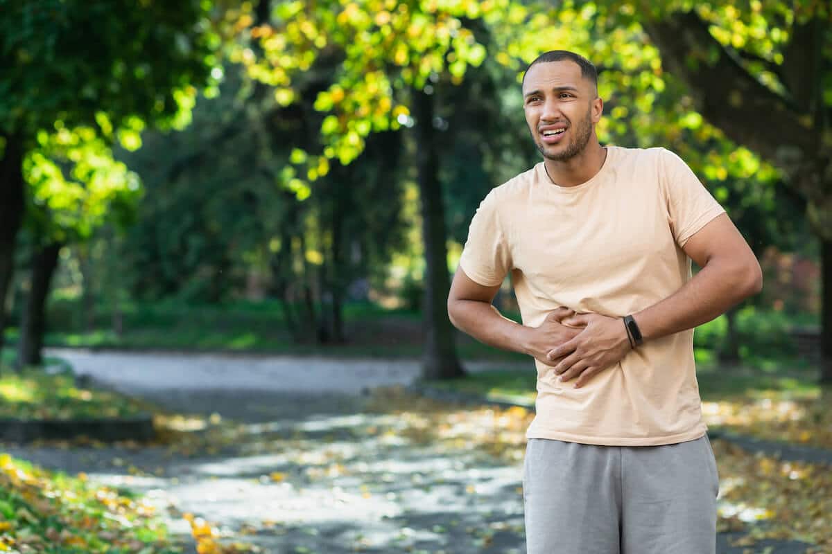 Best protein powder for sensitive stomach: man holding his stomach