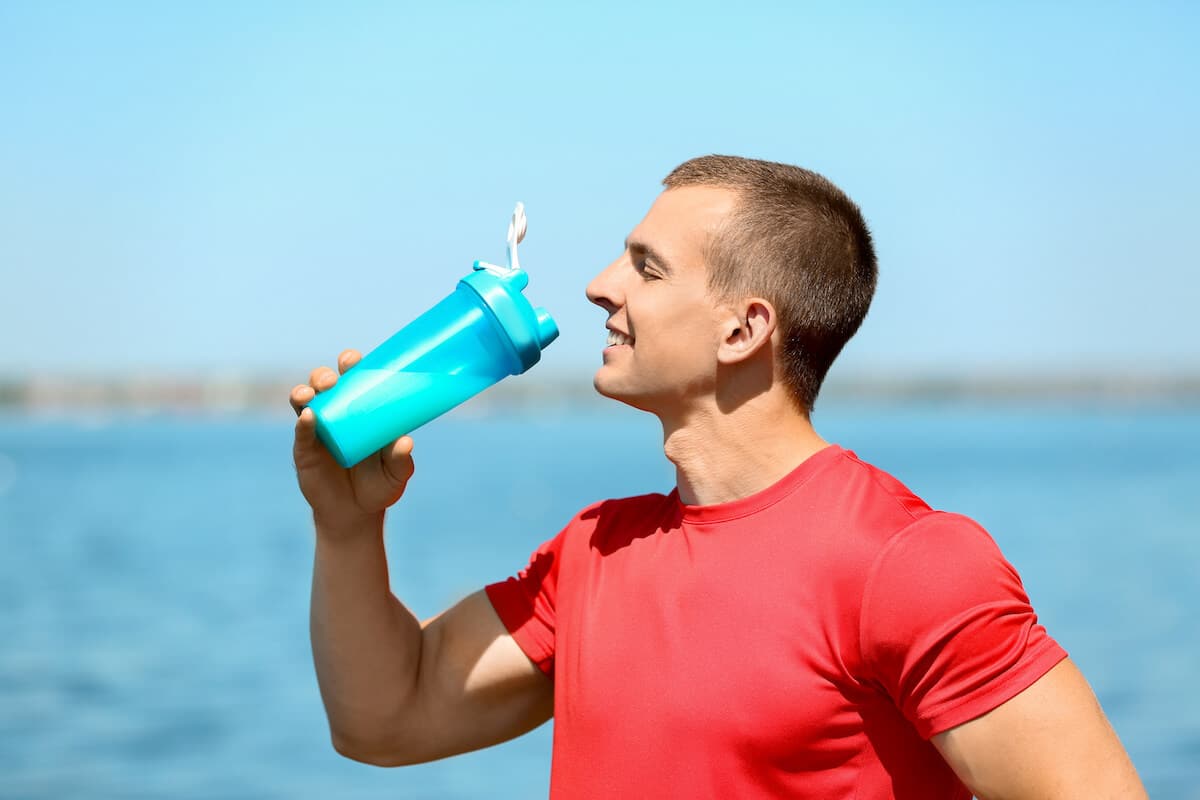 Should you drink protein shakes on rest days: man drinking from his tumbler